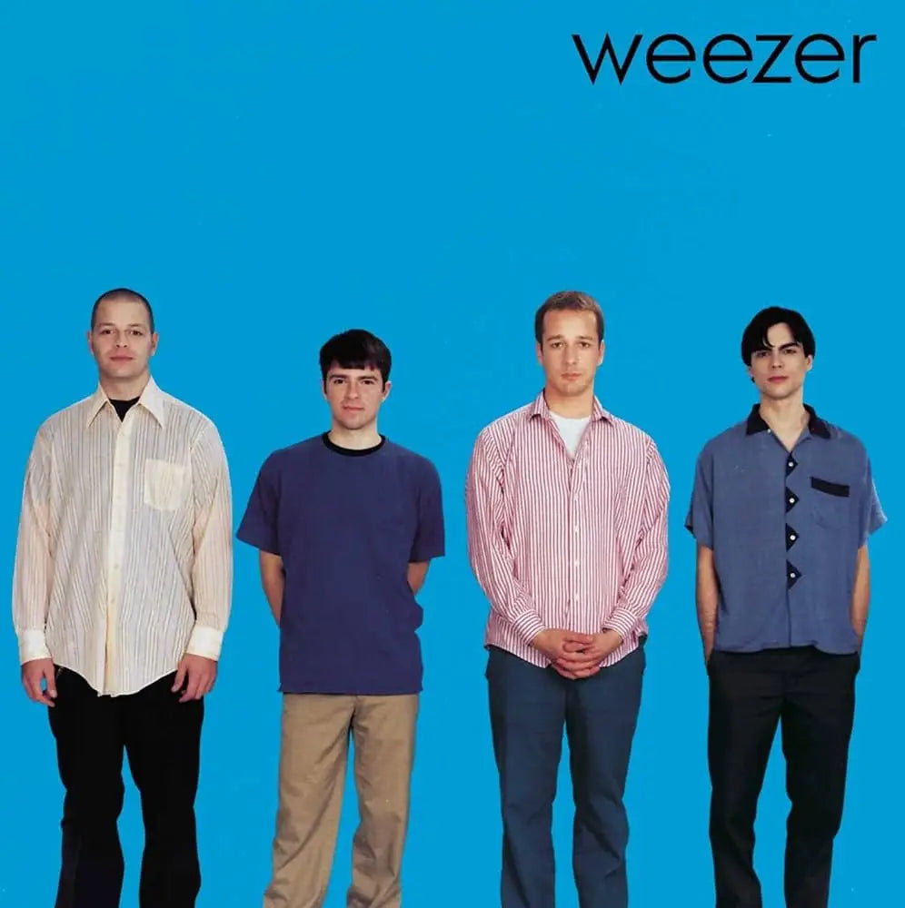 Weezer album cover featuring four band members against a solid blue background.
