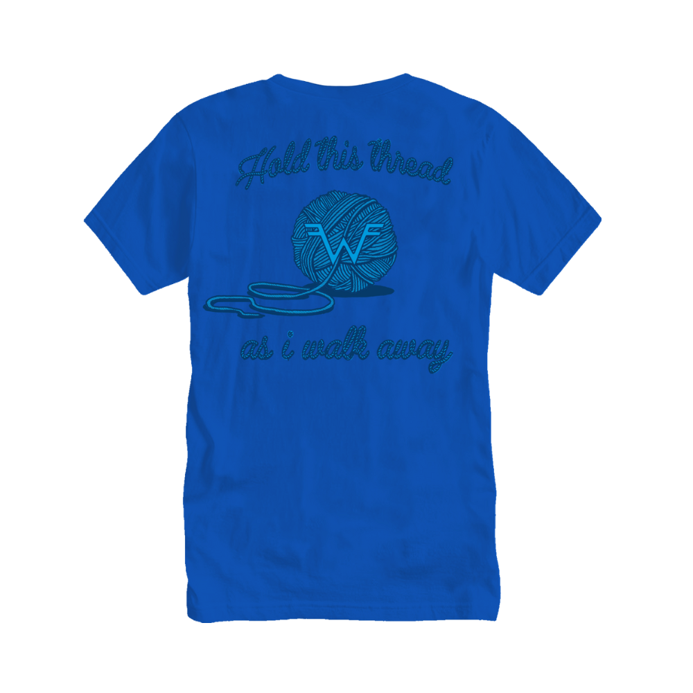 A vibrant blue cotton t-shirt featuring a teal embroidered design of a yarn ball with the text ’hold this thread as i walk away’ above and below it.