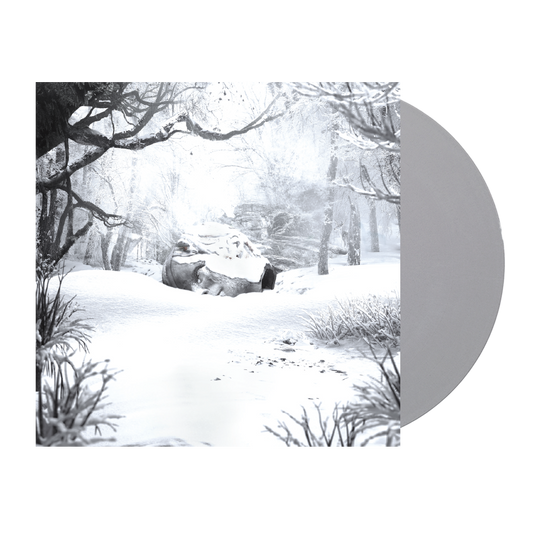 Snow-covered winter forest scene with bare trees and a rock formation.